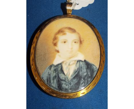 An oval bust portrait miniature, of a boy wearing a blue coat, watercolour, 6.5 x 5 cm, in a yellow coloured metal frame, wit