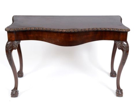 A George III style serpentine front serving table, on leaf carved cabriole legs with claw and ball feet, 122 cm wide  See ill