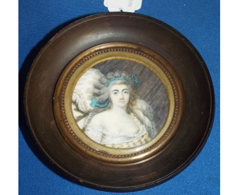 A bust portrait miniature, of a lady with a blue ribbon in her hair, watercolour, dated 1789, 6 cm diameter