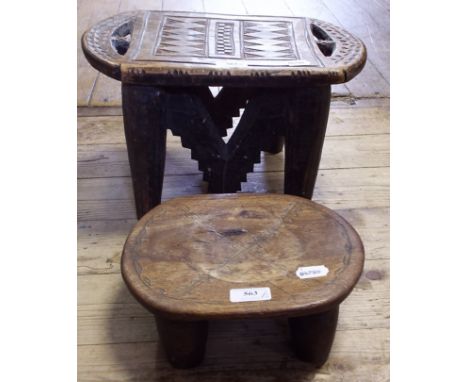 An African tribal stool, with carved decoration, 38 cm wide, and another similar, 26 cm wide (2)