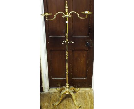 A lacquered brass floor standing two light candle holder