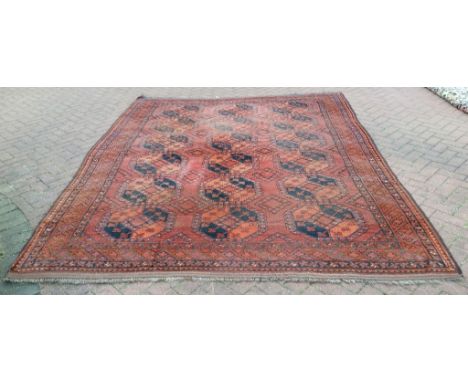 An Afghan carpet, with geometric motifs on a red ground, 314 x 248 cm