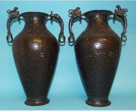 An Islamic brass vase, with beast handles, and traces of enamel decoration, 41.5 cm high, and another matching, with similar 