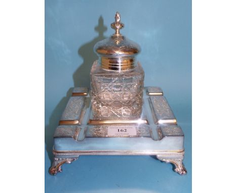 A plated desk stand, with central glass inkwell, 18 cm wide