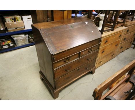 George III Oak Bureau, the drop front writing surface opening to reveal a fitted interior, over Two Short and Three Long Draw