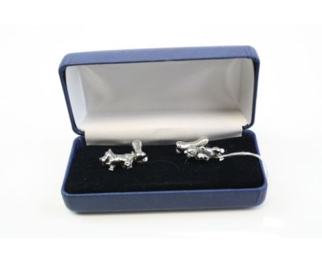 A pair of silver dog and bone cufflinks.