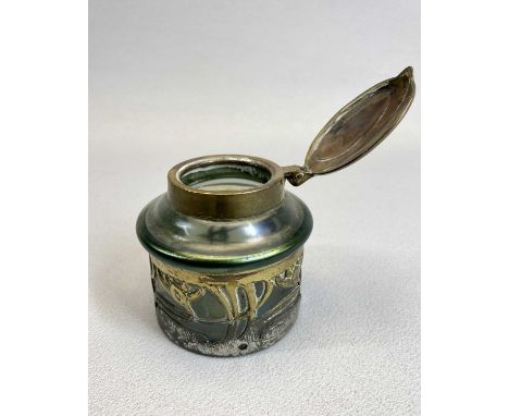 AN ART NOUVEAU 'LOETZ' STYLE IRIDESCENT GREEN GLASS INKWELL - of cylindrical form, pierced metal mounts and hinged brass cove