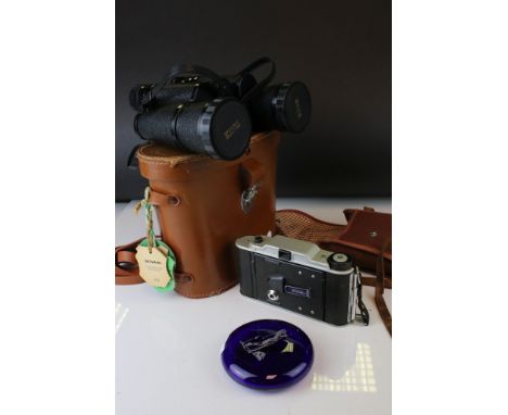 A pair of cased binoculars together with a Coronet folding camera and a golfing paperweight. 
