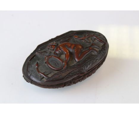 A carved wooden clam shell snuff box with angelic decoration.