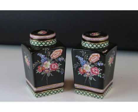 A pair of antique ceramic lidded black ground vases of square form with floral decoration 23 cm tall. 