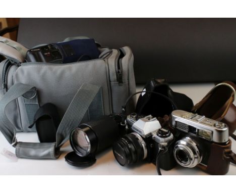 A collection of cameras and photographic equipment to include an Olympus OM10 35mm SLR camera. 