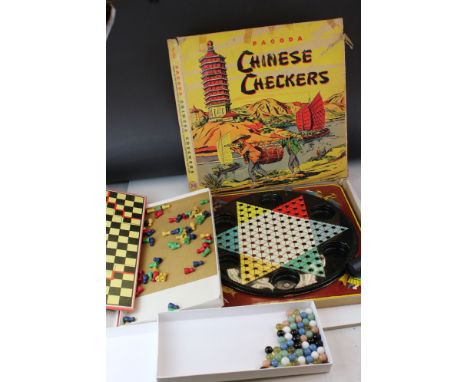 A vintage boxed Chinese Checkers game one other similar and a quantity of solitaire marbles.