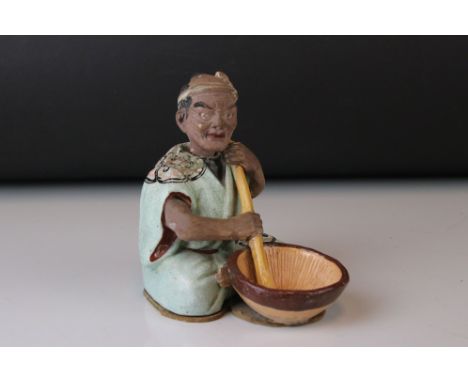 An early 20th century ceramic figure of a Buddhist monk in robes with singing bowl and nodding head. approx 12cm in height. 