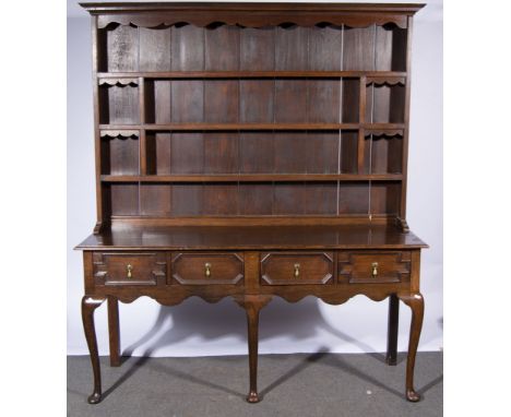 George lll style oak dresser, with a three shelf delft rack, the base with four frieze drawers each with recessed geometric m