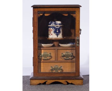 Edwardian oak smokers cabinet, rectangular top with a moulded edge, glazed door enclosing an interior fitted with drawers and