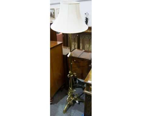 Edwardian brass standard lamp, scrolled tripod base, adjustable column, with shade, current height 180cm.