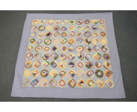 Patchwork quilt, 'Fluffy Circles', circa 1999, a raw edged 'scrappy' quilt, on a light blue ground, signed by Anna Holleron, 