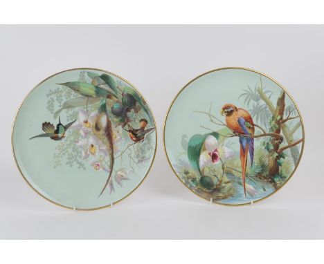 Pair of hand decorated ceramic plaques, circa 1890, decorated with exotic birds in colours, over a printed ground, both signe