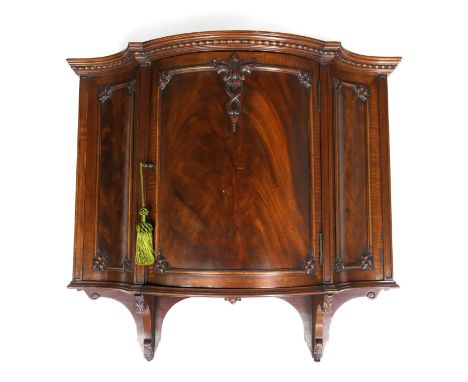 Quality late Victorian mahogany wall cabinet, circa 1890, the bow fronted flame mahogany door with carved mouldings edged wit