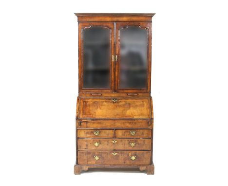 George I walnut bureau bookcase, circa 1710-20, the top with cavetto cornice over moulded glazed bookcase doors, opening to t