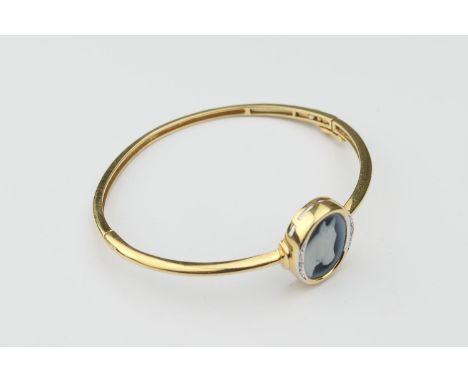 18ct gold equine cameo bangle,  the hinged bangle having an oval equine portrait cameo, collet set and flanked by two tiny di