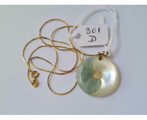 A smaller gold mounted jade disk pendant on 14ct gold chain 