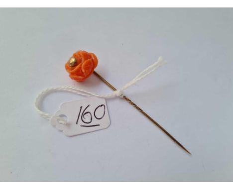 A carved coral rose 9ct stick pin