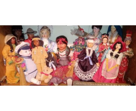 A shelf of costume &amp; other dolls