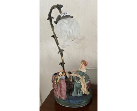 An electric metal table lamp with resin figure playing a piano