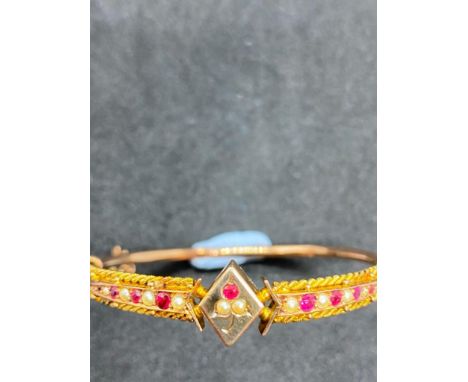 A ROSE GOLD ATTRACTIVE BANGLE MOUNTED WITH RUBY AND PEARL PANELS OF LOZENGE SHAPED CENTRE SET IN 9CT - 6.6 GMS 