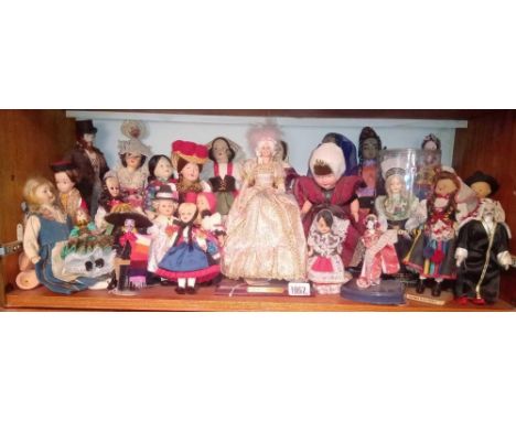 A shelf of oriental &amp; european dolls