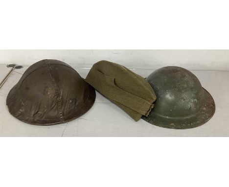 WWII British Brodie Helmets, comprising helmet with cover, liner and chinstrap and helmet with partial liner (bales and rudim