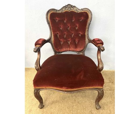 A Victorian red upholstered button back armchair with carved showwood frame raised on short cabriole legs, 94cm high