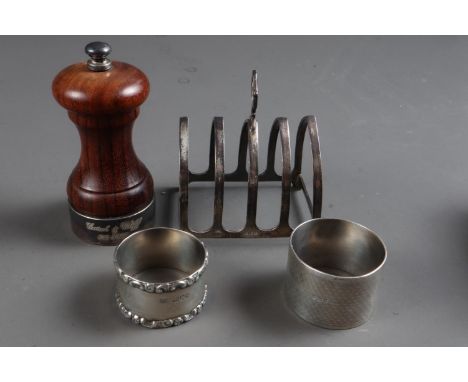 A silver mounted pepper grinder, two similar napkin rings and a silver toast rack, 5.1oz troy approx weighable