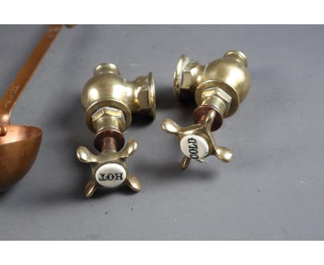 Two brass and copper taps, a copper ladle, brass ring handles and a quartz mantel clock