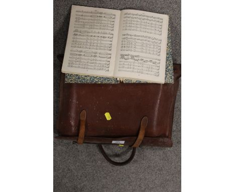 A VINTAGE LEATHER SATCHEL OF SHEET MUSIC