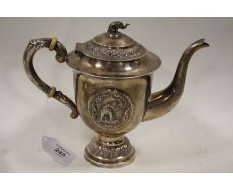 A WHITE METAL CONTINENTAL TEAPOT, decorated with two circular applied panels of an elephant with a raised trunk, together wit