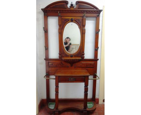 A Victorian carved walnut hall stand, with eight brass hooks, centred by a mirror over drawer and double stick stand, 113cm w