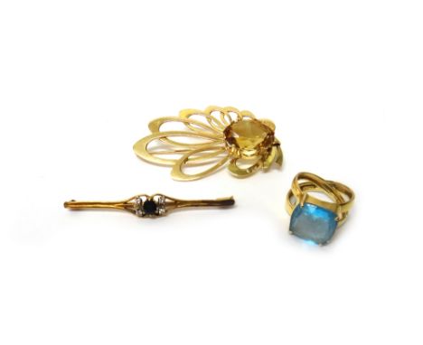 A gold ring, mounted with a cushion shaped blue topaz, detailed 750, ring size S, gross weight 7.6 gms, a gold brooch, claw s