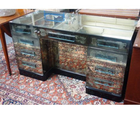 A mirrored pedestal desk, first half 20th century, with nine drawers about the knee on plinth base, 135cm wide x 61cm deep. 