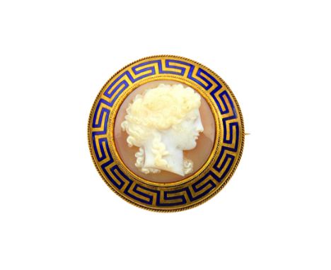 A Victorian gold and blue enamel mounted carved agate cameo brooch, carved as a classical portrait within a Greek key pattern