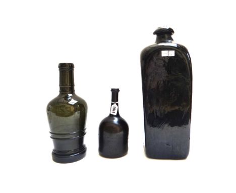 An 18th century green glass wine bottle, with slender neck and inverted base, 23cm high, a large 19th century green glass gin