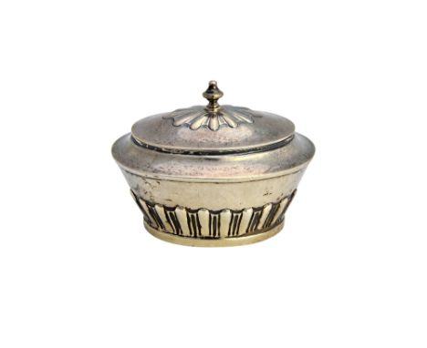 A silver oval hinge lidded tea caddy, of sarcophagus form, with partly fluted decoration and with a finial to the lid, London