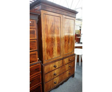 A George III mahogany linen press, with pair of doors enclosing four trays, over two short and two long drawers, on bracket f