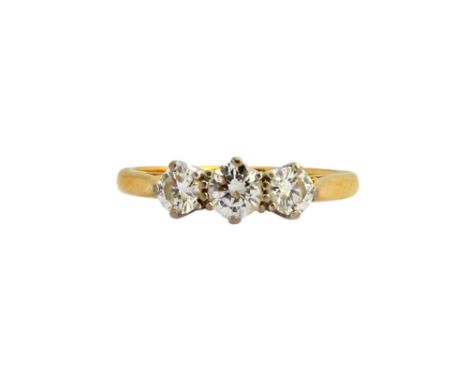 An 18ct gold and diamond three stone ring, claw set with a row of circular cut diamonds and with the principal diamond mounte