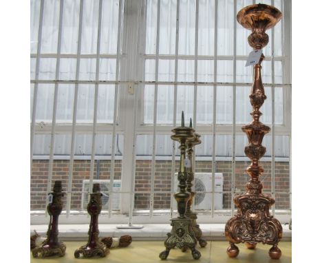 A copper altar candlestick, possibly 18th century, foliate embossed on a triform base (103cm high) and a pair of 19th century