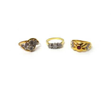 An 18ct gold and diamond set three stone ring, mounted with a row of circular cut diamonds and with the principal diamond mou