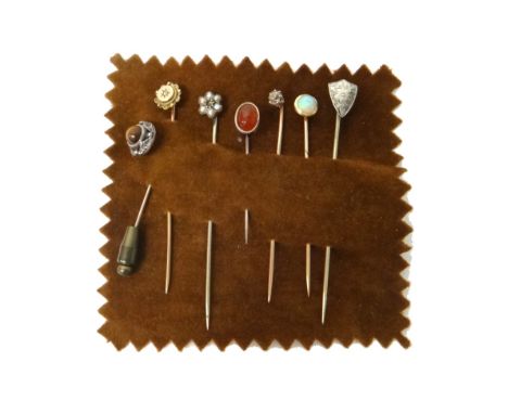 A gold and opal topped stick pin, a diamond set single stone stick pin, a tiger's eye stick pin, a cornelian stick pin and th