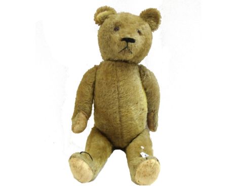 A Steiff style teddy bear, early 20th century, with golden fur and jointed limbs, 63cm.