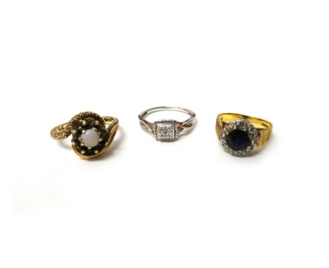 An 18ct gold, sapphire and diamond cluster ring, claw set with the circular cut sapphire at the centre, in a surround of eigh